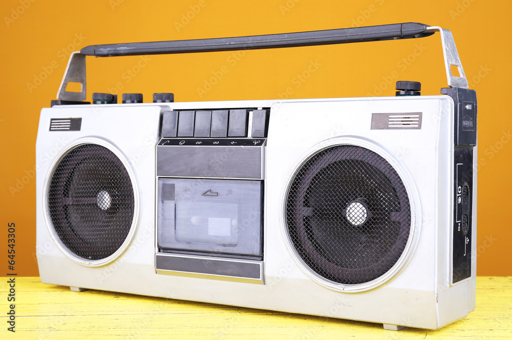 Retro cassette stereo recorder on table on yellow background Retro cassette stereo recorder on table on yellow background