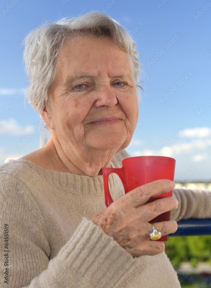 Senior woman drinking tea - outdoors. Senior woman drinking tea - outdoors.
