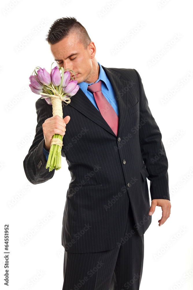 Thinking young man holds bouquet of tulips and sniffs her Thinking young man holds bouquet of tulips and sniffs her