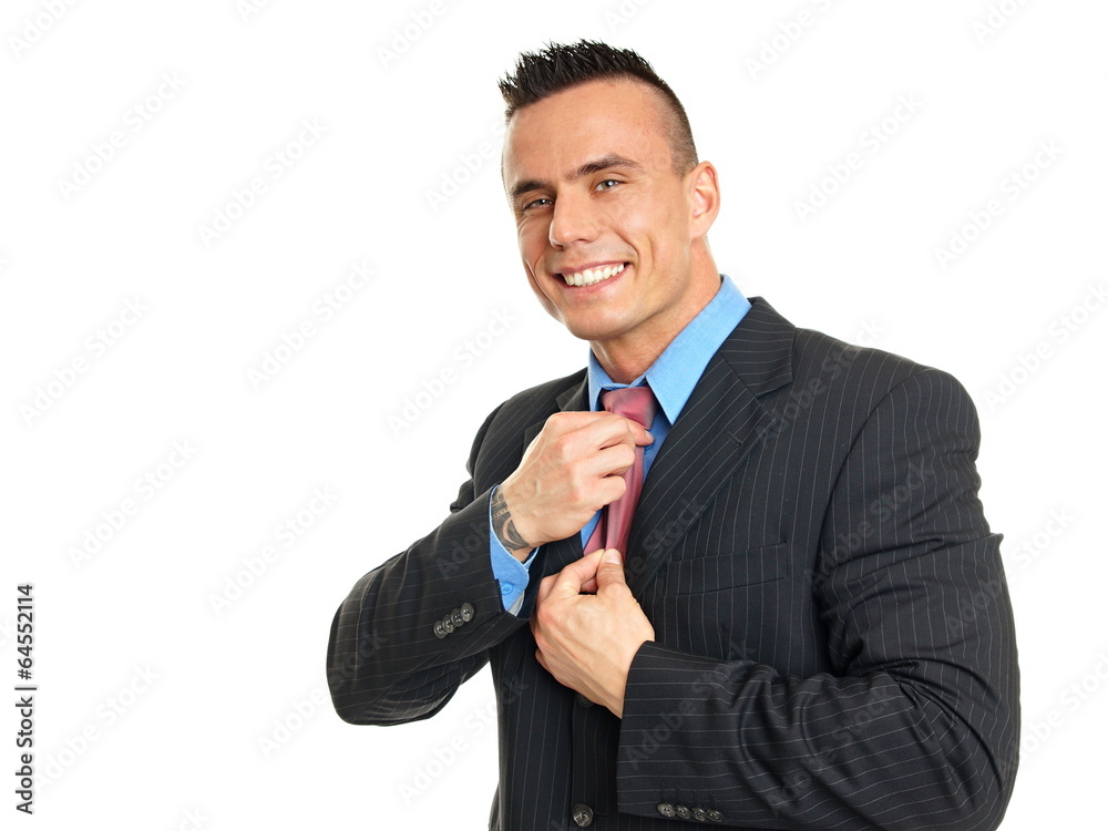 Young smiling businessman adjusts a tie against white background Young smiling businessman adjusts a tie against white background