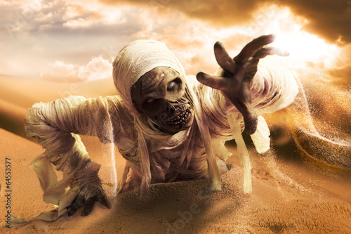 Scary mummy in a desert at sunset