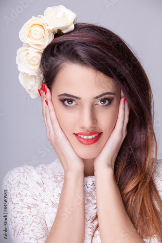 Gorgeous woman with flowers in head on grey background