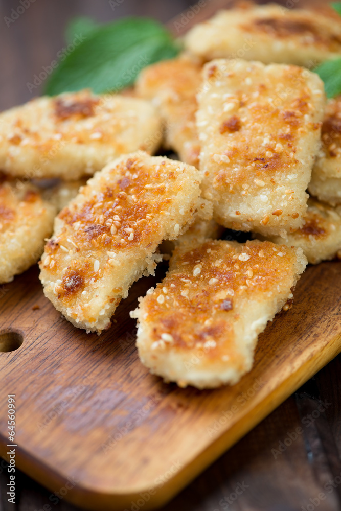 Sesame chicken nuggets on a rustic cutting board Sesame chicken nuggets on a rustic cutting board