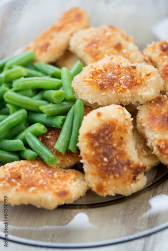 Sesame chicken nuggets with beans, vertical shot, close-up
