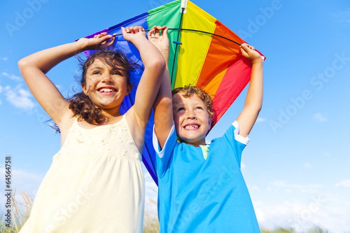 Little Girl And Little Boy Playing Kite Together