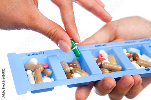 Tablet and capsule in daily pill box show medicine concept, isol