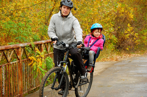 Father and kid on bike, cycling in autumn park