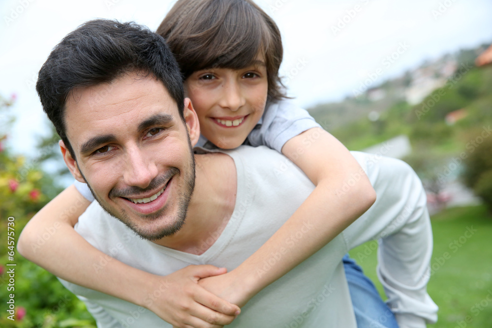 Father giving piggyback ride to his son