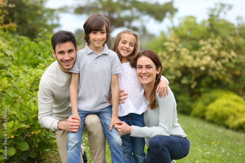 Portrait of cheerful family standing in home garden