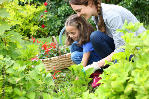 Little girl helping her mother to do gardening