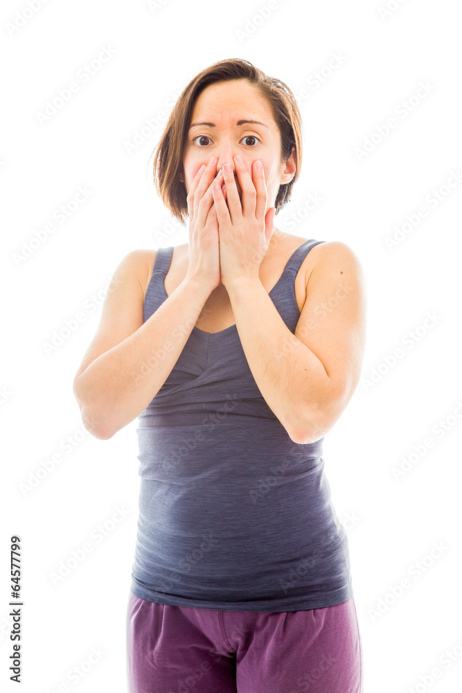 Young woman with hand over her mouth and shock Young woman with hand over her mouth and shock
