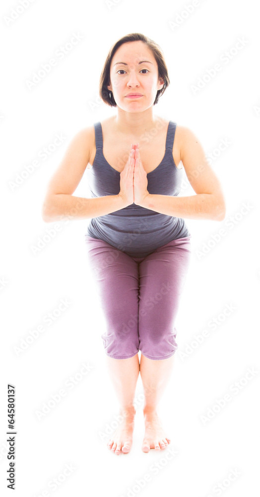 Young woman practicing yoga in chair pose Young woman practicing yoga in chair pose