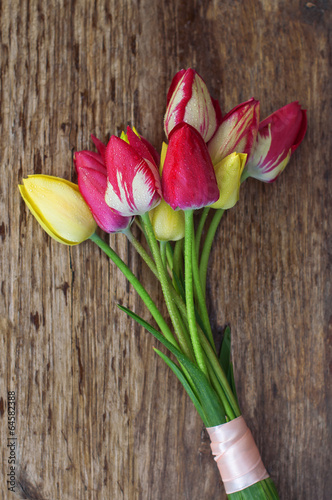 bouquet of multi-colored tulips on a wooden surface