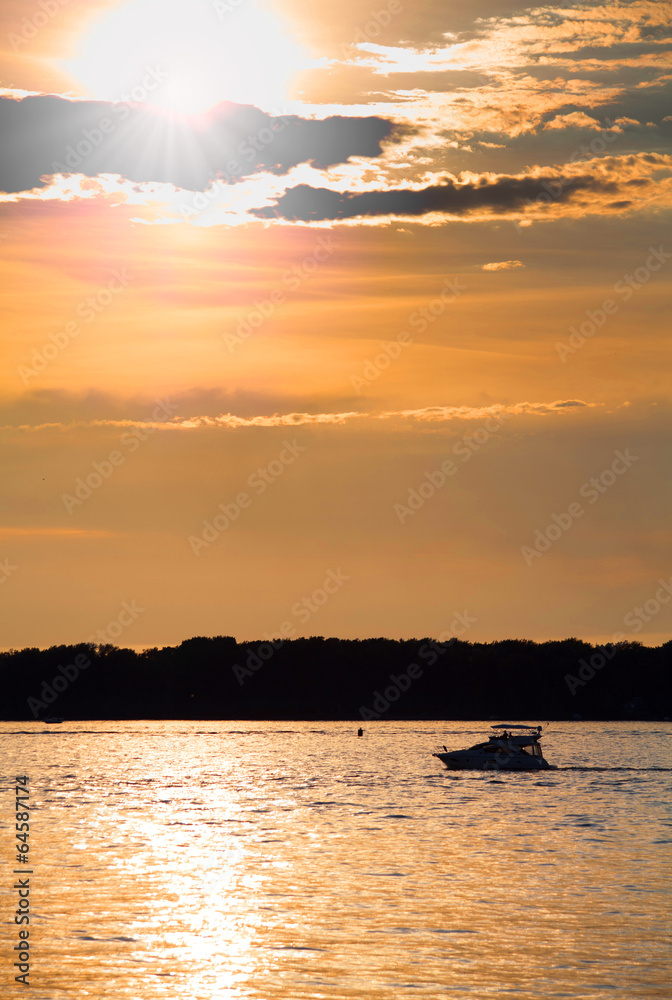 Cloudy sunset with silhouette of lonely boat