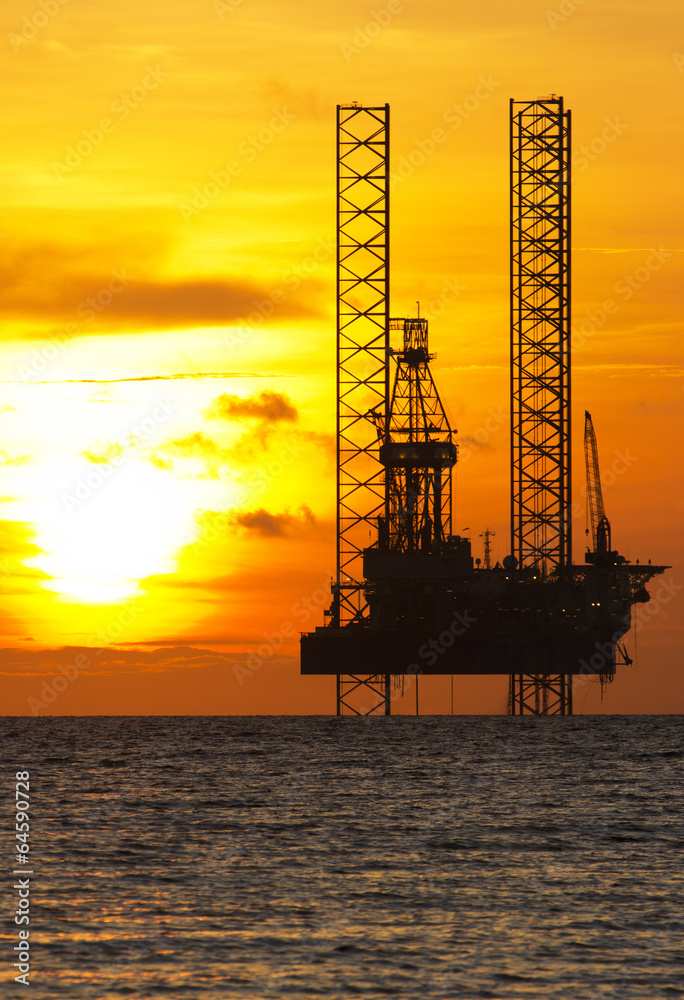 Silhouette of an offshore drilling rig at sunset