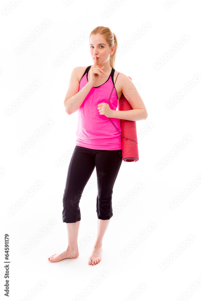 Young woman carrying exercising mat with finger on lips Young woman carrying exercising mat with finger on lips