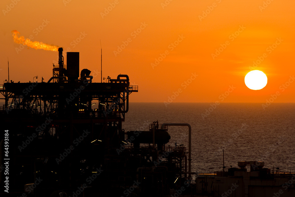 An offshore oil-platform with gas flare during sunset