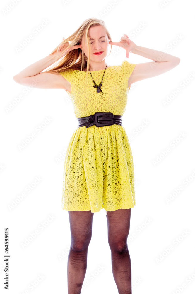 Young woman standing with fingers in her ears Young woman standing with fingers in her ears