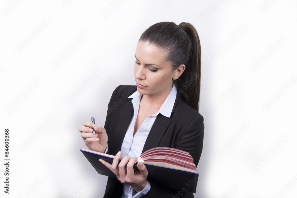 Serious business woman writing in her agenda / notebook Serious business woman writing in her agenda / notebook