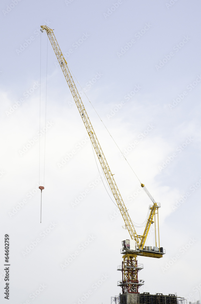 yellow hoisting crane on blue sky background