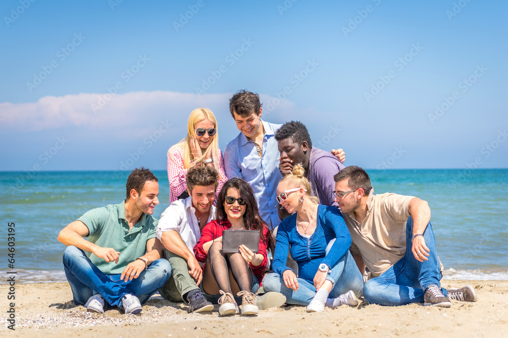 Friends on the beach looking tablet Friends on the beach looking tablet
