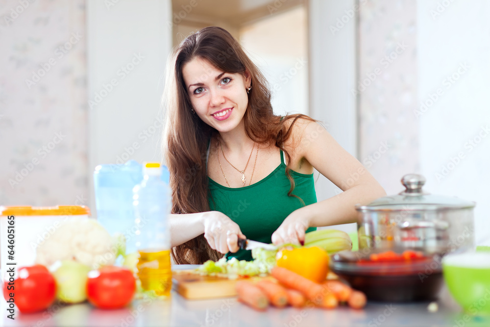  woman cutting vegetables at  kitchen