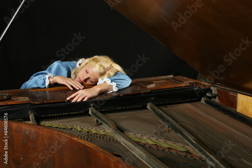 Baroque woman sleeping onon an old grand piano photo