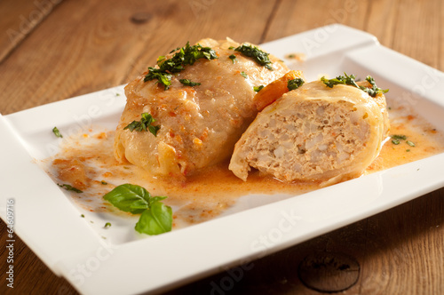 Closeup of stuffed cabbage rolls with tomato souce and herbs