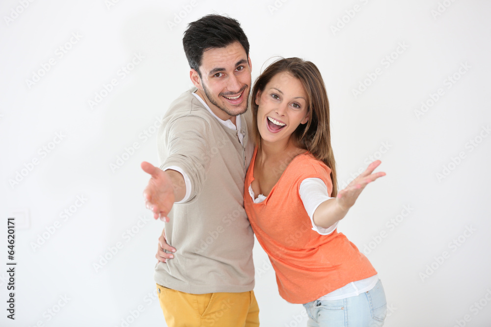Cheerful couple spreading arms towards camera Cheerful couple spreading arms towards camera