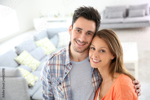 Cheerful young loving couple at home