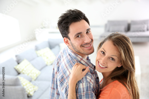 Cheerful young loving couple at home