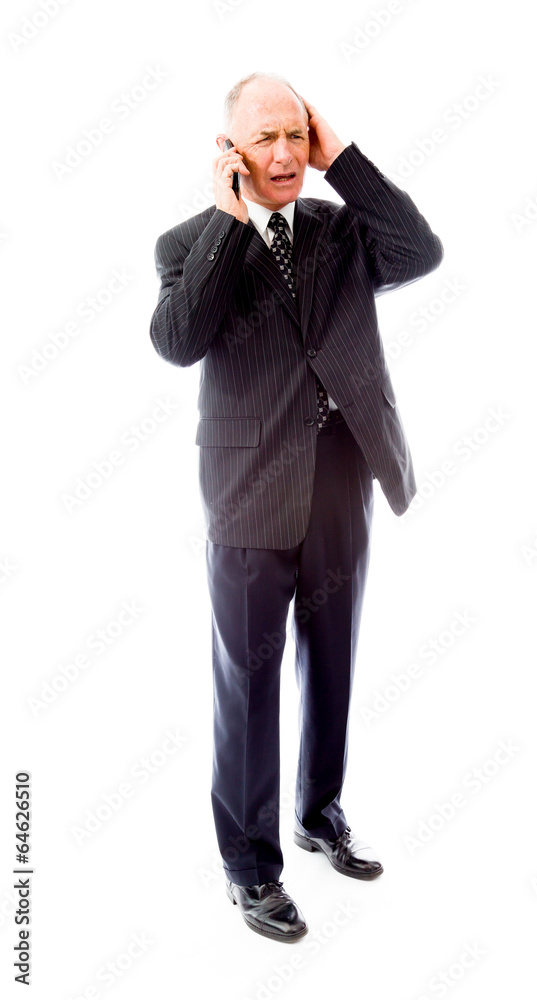 Businessman talking on a mobile phone and looking worried Businessman talking on a mobile phone and looking worried
