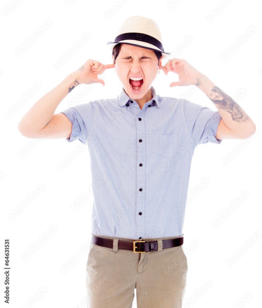 Young woman standing with fingers in her ears Young woman standing with fingers in her ears