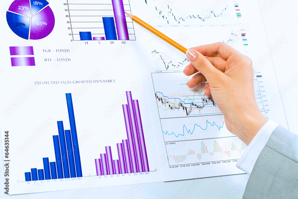 female hand pointing pencil on financial charts female hand pointing pencil on financial charts