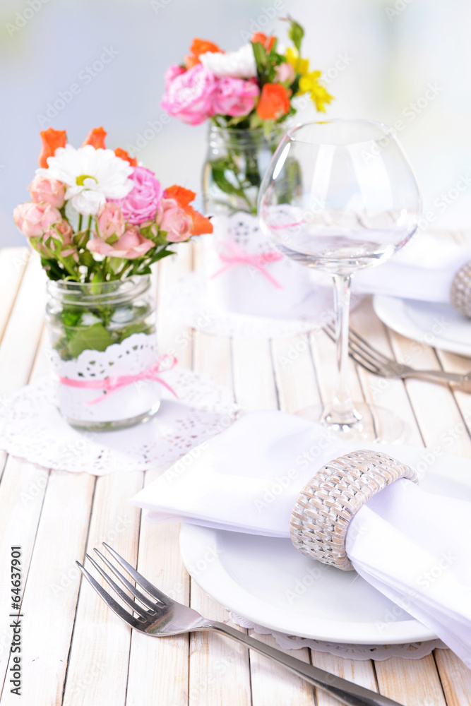 Fototapeta premium Beautiful table setting with spring flowers in jar close-up
