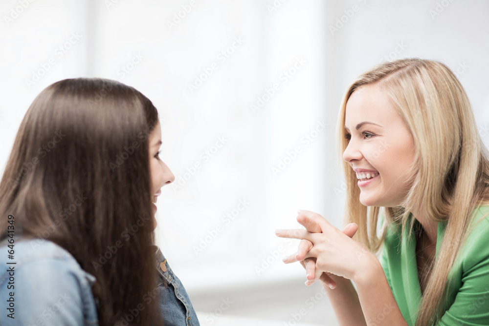 student girls gossiping at school student girls gossiping at school