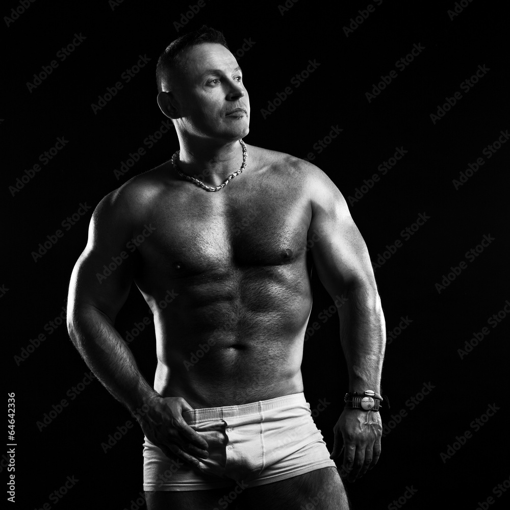 Bodybuilder in the studio on a black background Bodybuilder in the studio on a black background