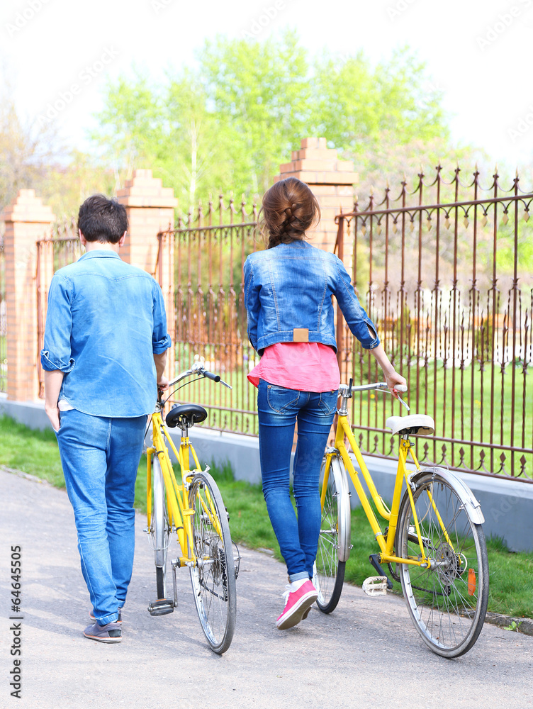 Obraz premium Young couple with bicycles outside