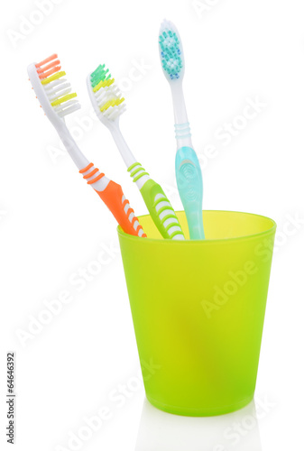 Toothbrushes in glass isolated on white