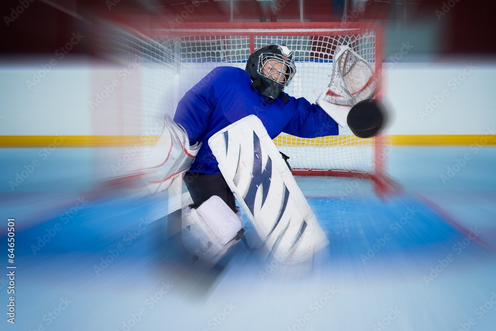 Fototapeta premium Young hockey goalie catching a flying puck