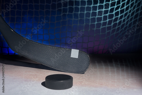 Carbon hockey stick on ice, against smoky background