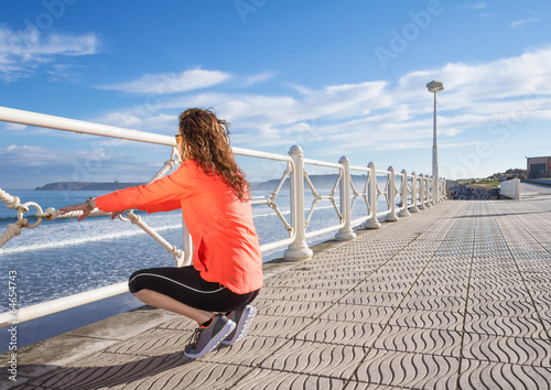 Young girl warming before running in a promenade