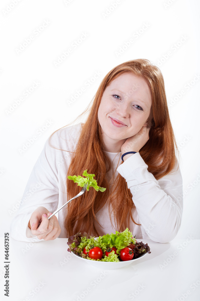 Girl with fork in hand eating vegetable Girl with fork in hand eating vegetable