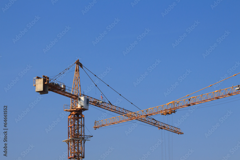 Yellow crane elevating with blue sky background