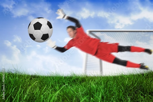 Fit goal keeper jumping up saving ball © WavebreakmediaMicro