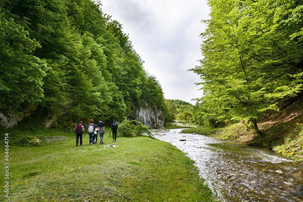 Fototapeta premium Hikers group cross the mountain river ford
