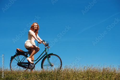 Red-hair woman riding a bicycle