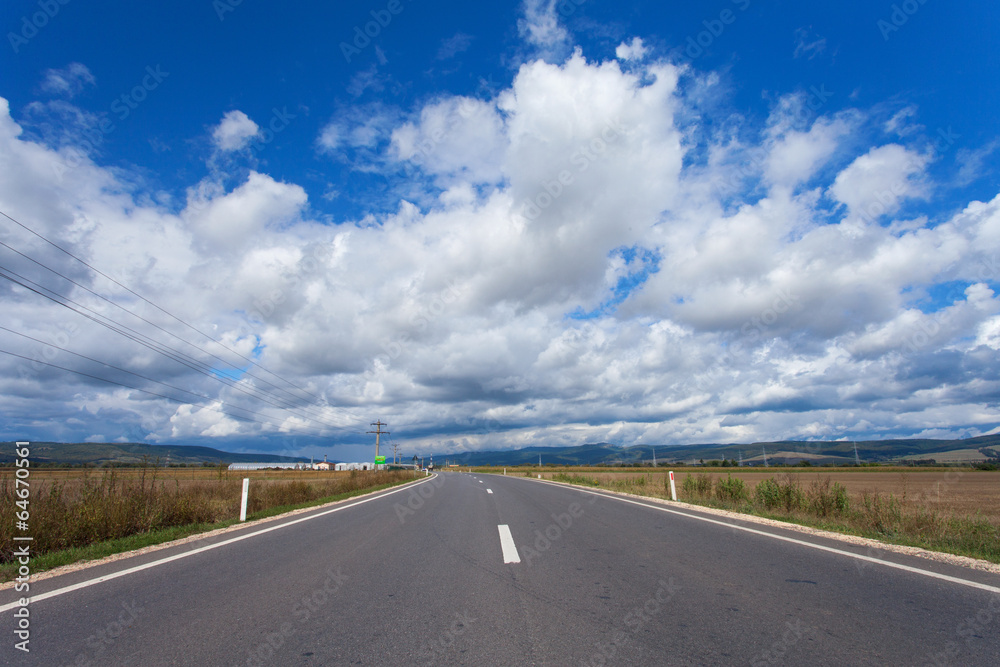 Fototapeta premium A country highway under a bright blue sky.