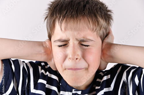 Young boy covering his ears with hands