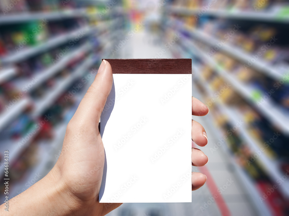 white blank notebook in woman hand and supermarket background white blank notebook in woman hand and supermarket background